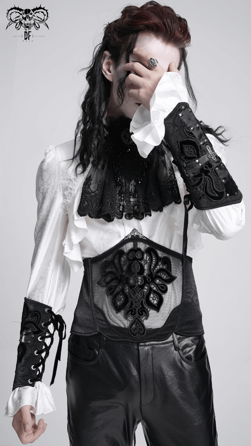 Gothic fashion model wearing an intricate black and white outfit with lace and corset details, embodying alternative style.