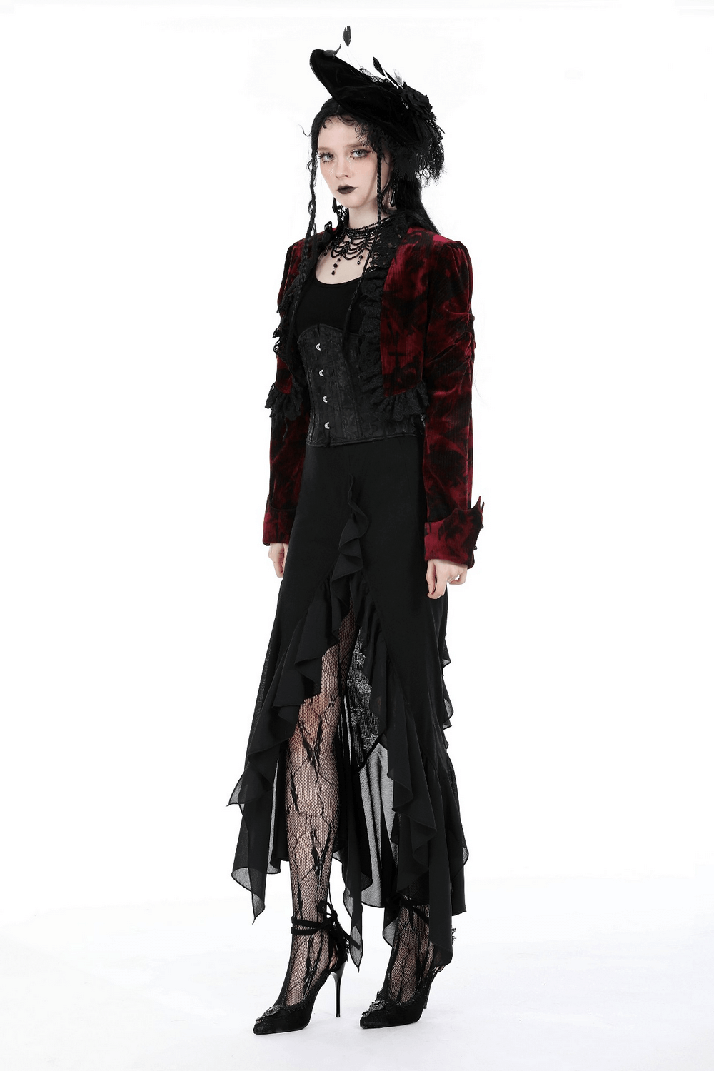 Chic model in asymmetrical black long skirt with ruffles and red velvet jacket, showcasing a gothic fashion style.