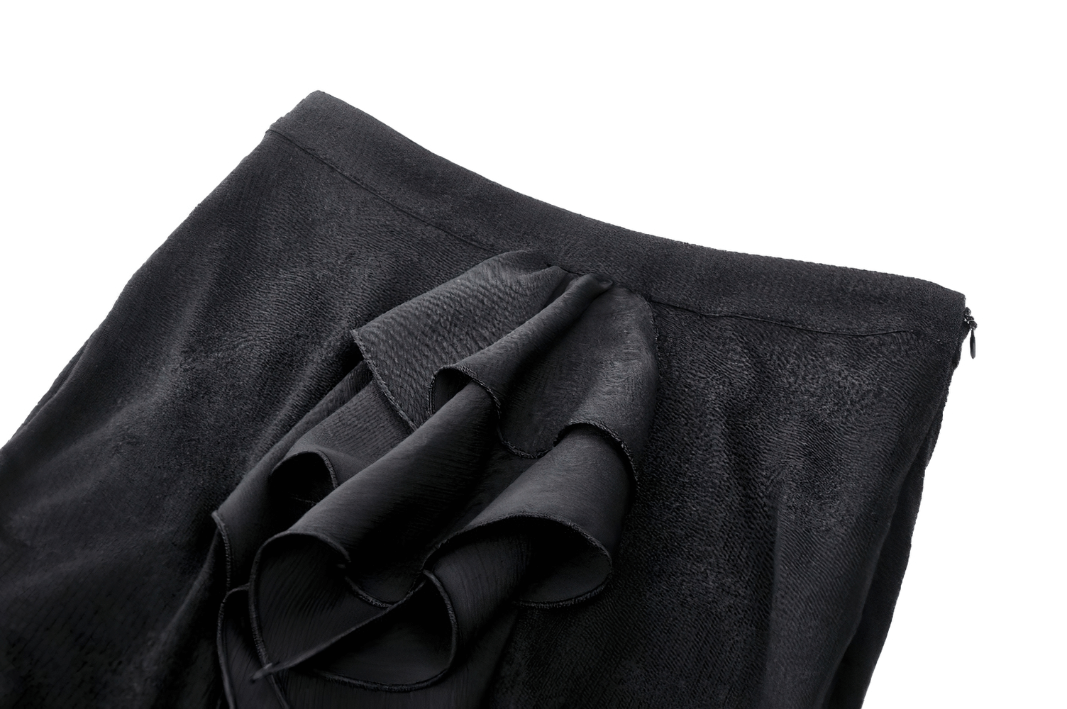 Close-up of an elegant black skirt with asymmetrical ruffles and soft fabric, showcasing its flowy design.