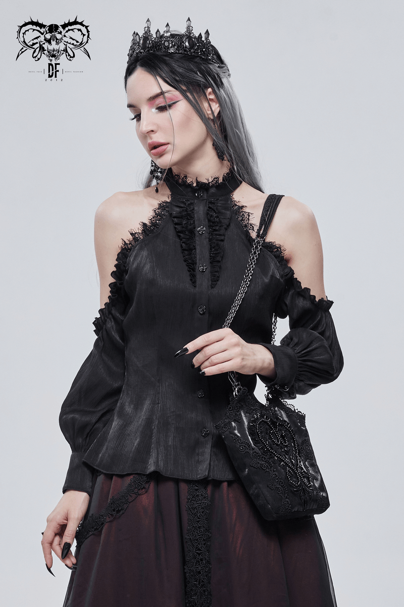 Gothic-style woman in black blouse and crown holding an elegant black bag with guipure and chain accents.