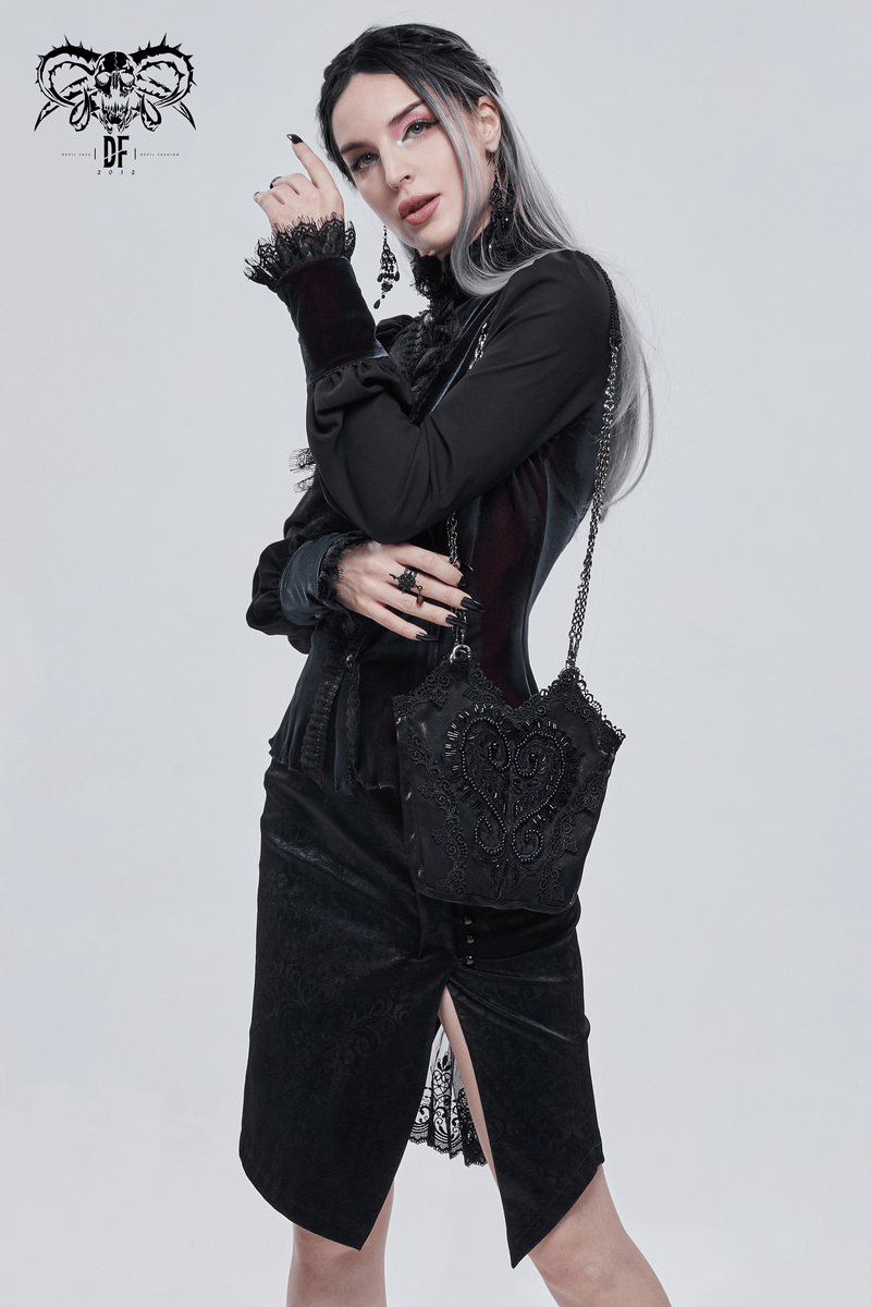 Stylish woman in gothic black outfit holding an elegant floral bucket bag with chain accents.