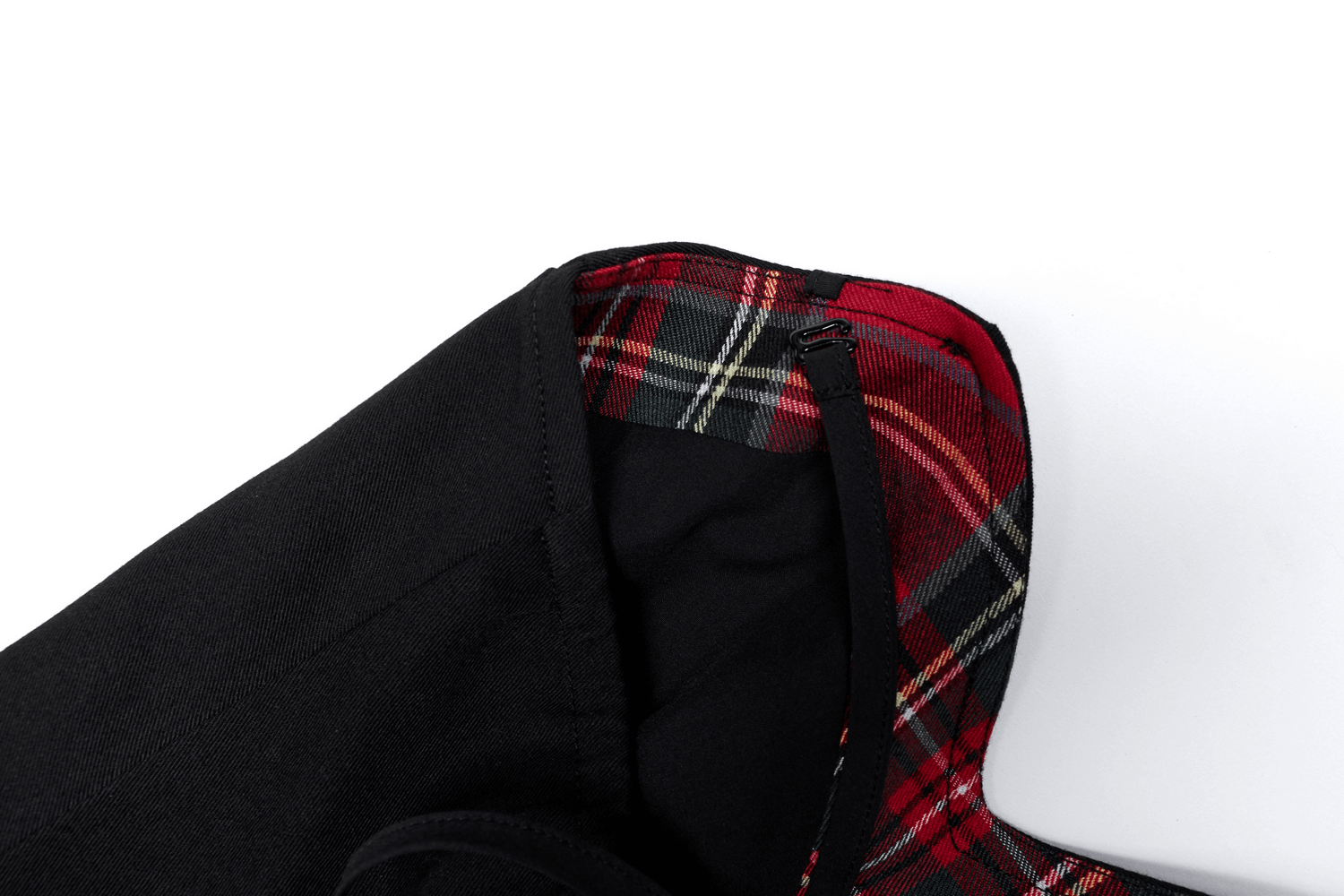 Close-up of elegant black dress with red plaid interior showcasing stylish design details.