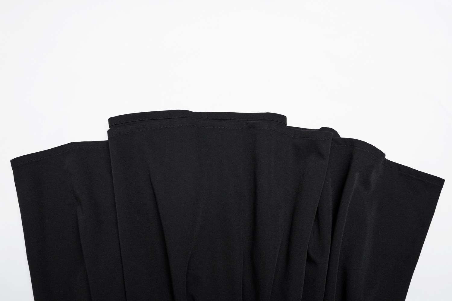 Elegant black fabric showcasing the pleated hem detail of a stylish A-line skater dress.