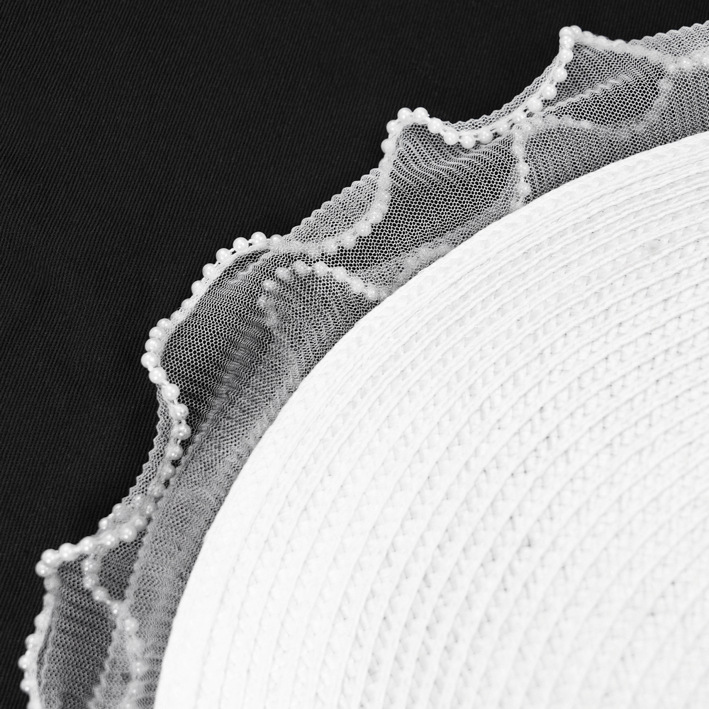 Elegant black and white lace fascinator hat detail with a frilled edge and soft texture.