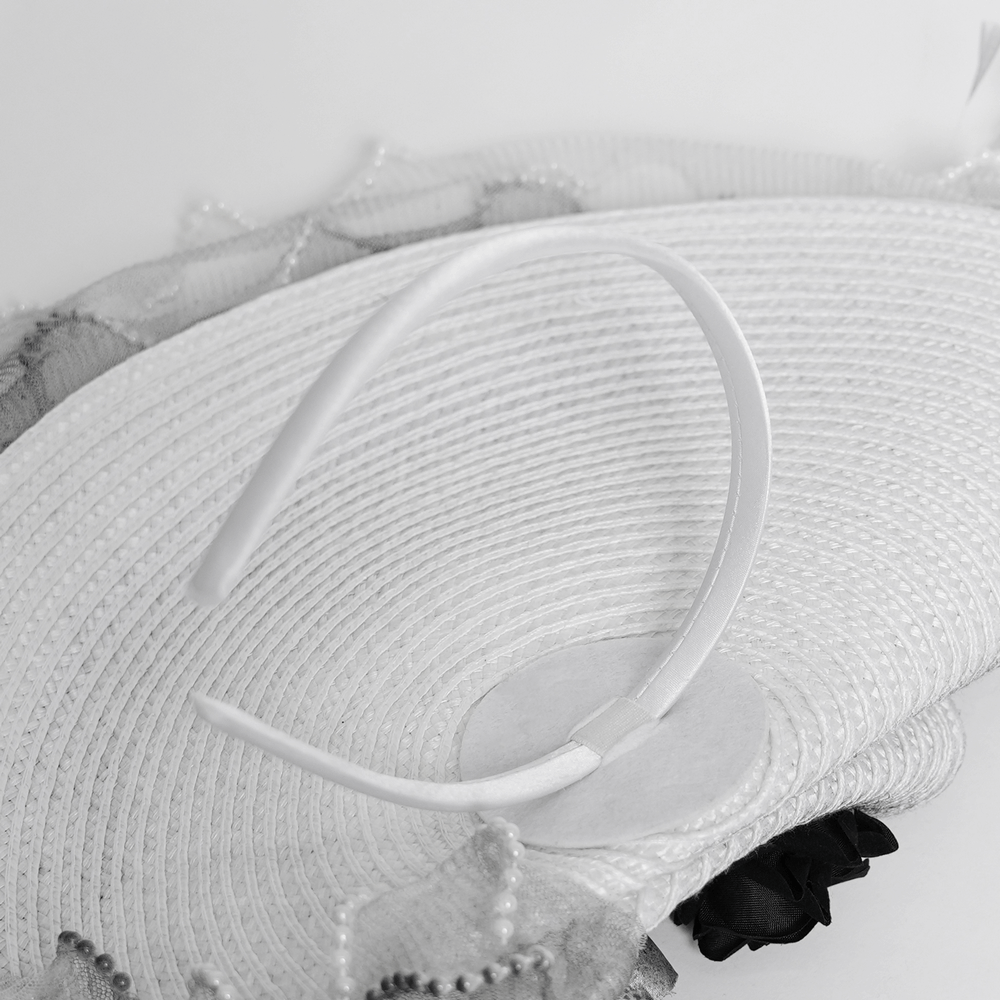 Elegant black and white floral fascinator hat with feathers, showcasing intricate lace and floral details.