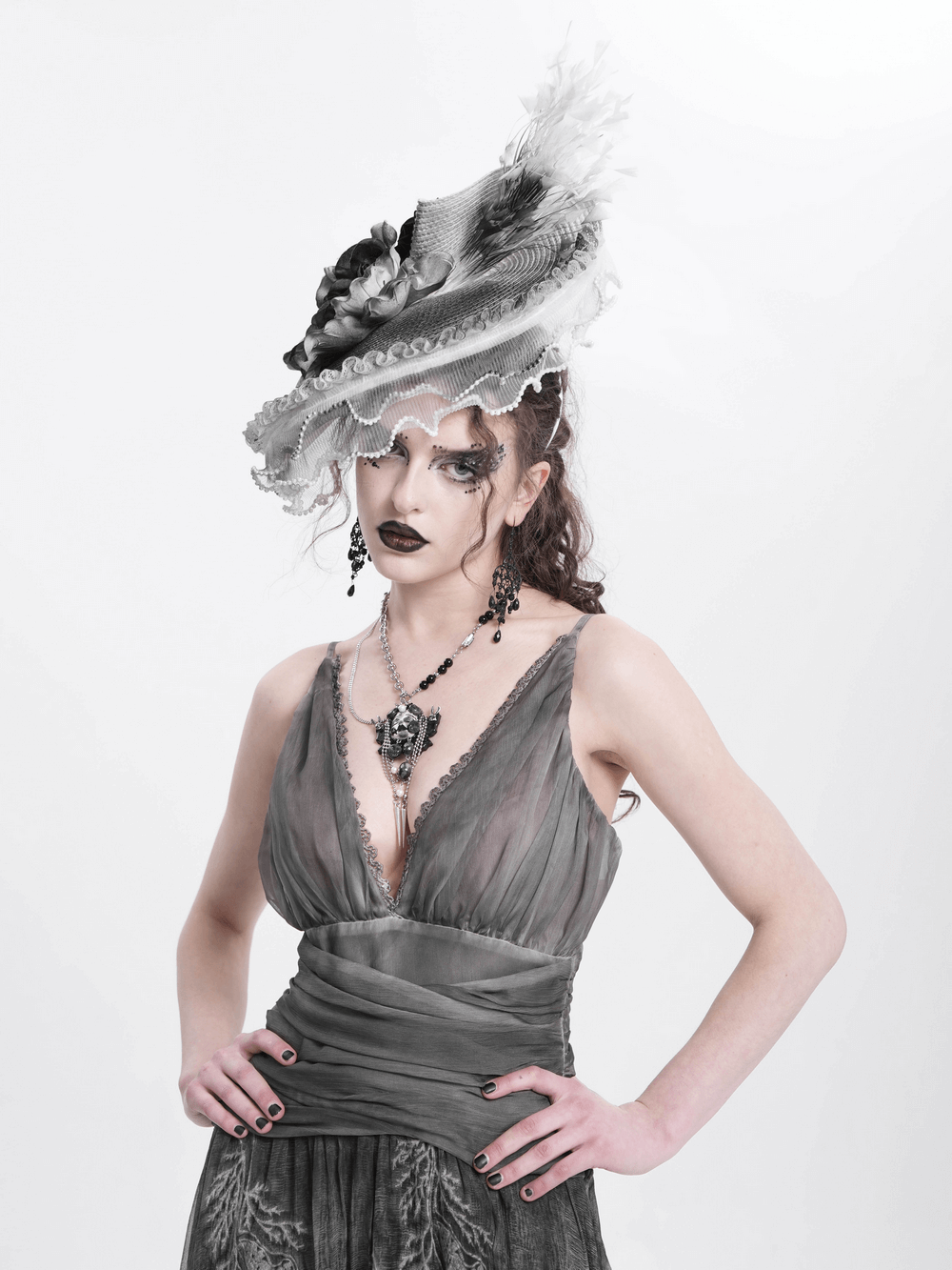 Elegant black and white floral fascinator hat with feathers, adding gothic charm to a vintage-inspired outfit.