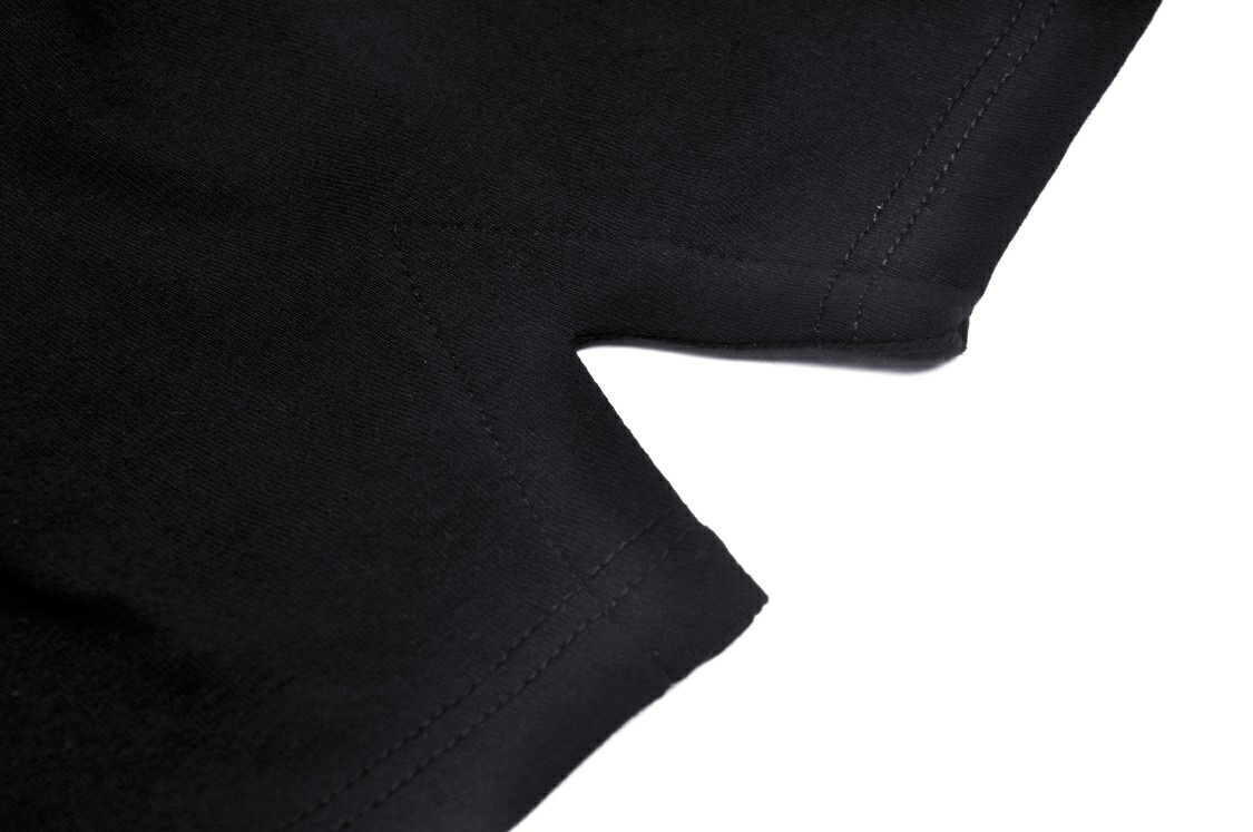 Close-up of elegant black crop top showing detailed stitching and unique neckline design, perfect for modern fashion.