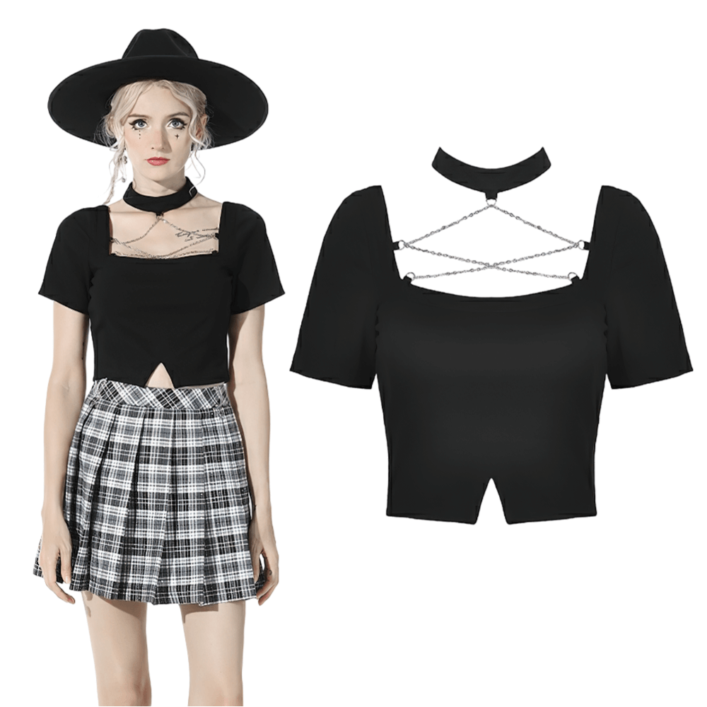 Elegant black crop top with unique neckline and chain detail, paired with a stylish skirt and hat.