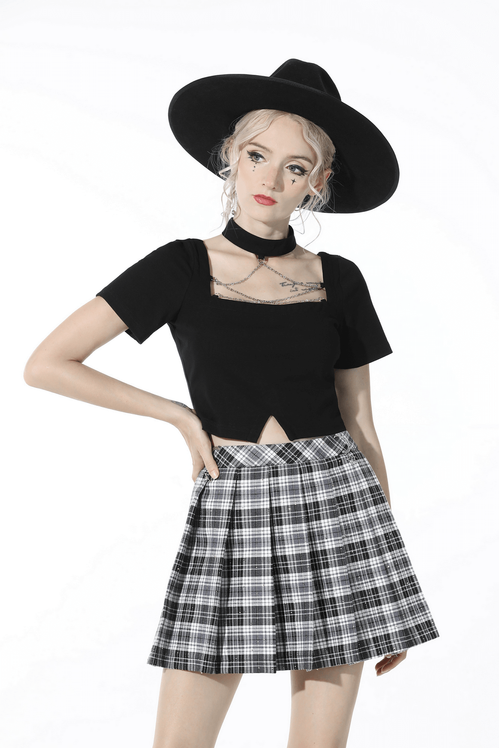 Chic model wearing an elegant black crop top and plaid skirt, showcasing a fashionable neckline and stylish accessories.