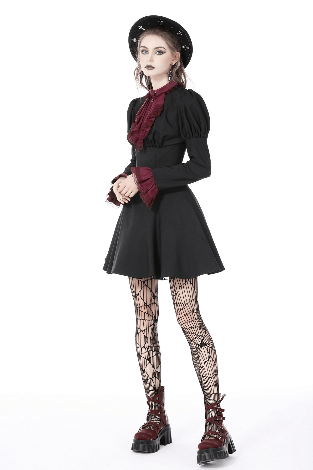 Vintage-inspired black dress with burgundy lace and lace-up detail, styled for a sophisticated evening look.