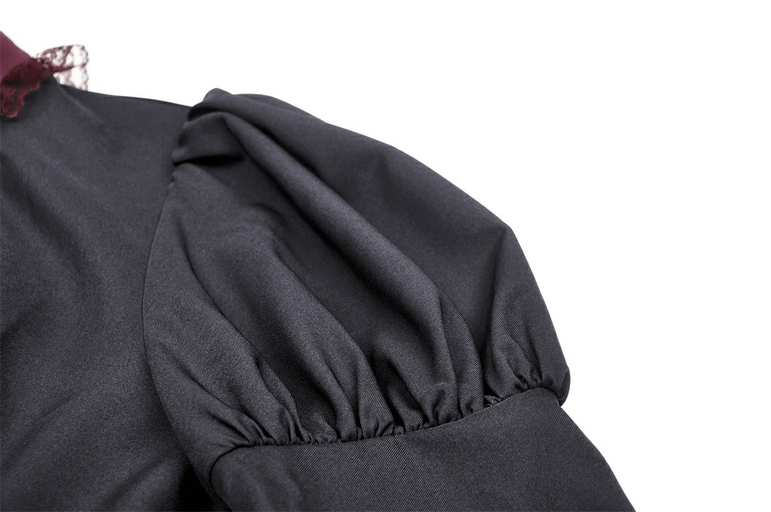 Close-up of elegant black dress sleeve with burgundy lace detail and pleated design, perfect for vintage-inspired fashion.