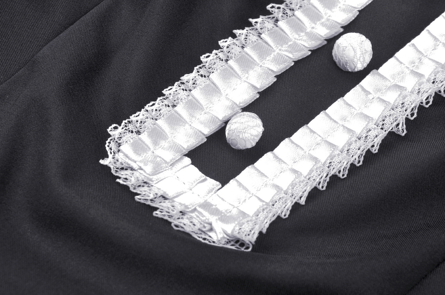 Close-up of elegant black dress with white lace collar and cuff detailing, showcasing vintage-inspired design.