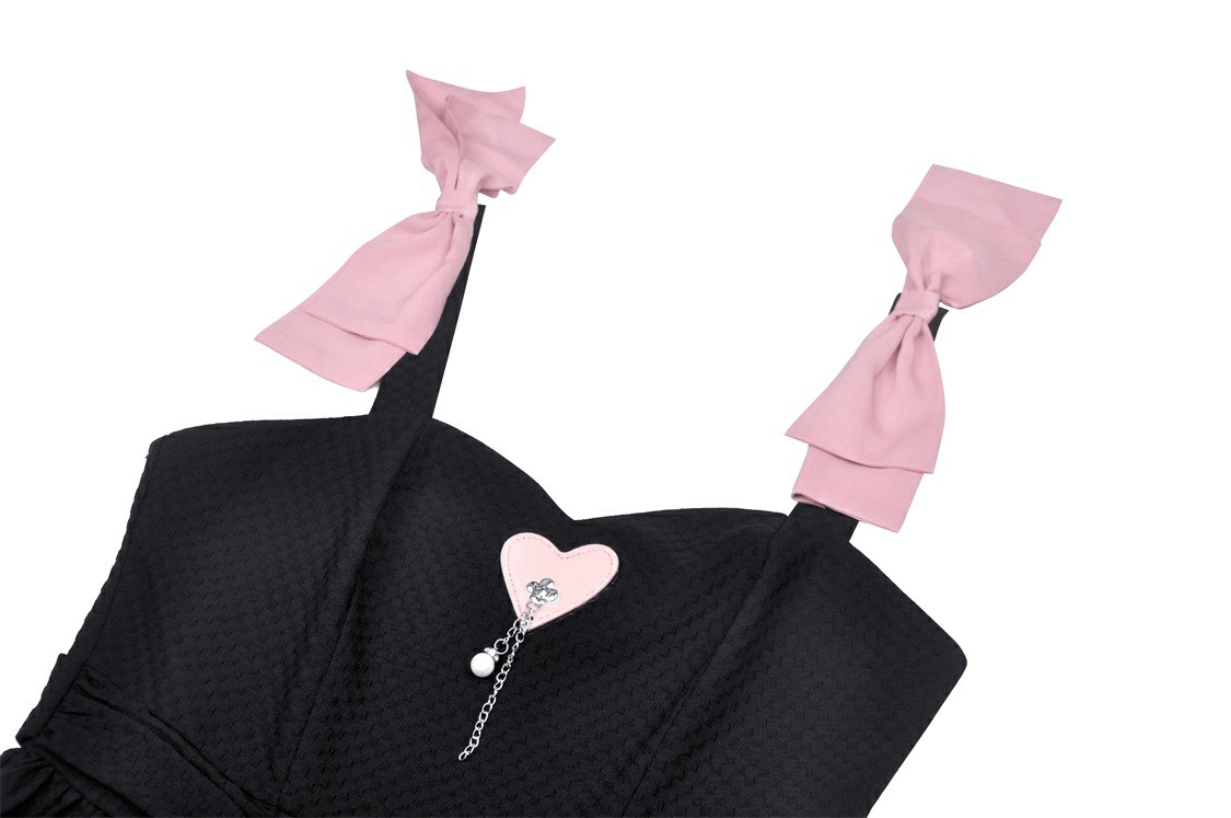 Elegant black dress with playful pink ribbon straps and heart pendant, perfect for chic parties.