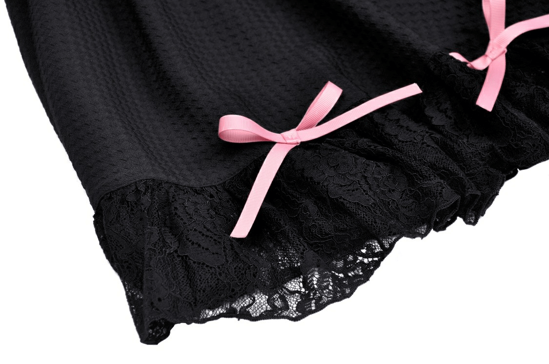 Elegant black dress hem featuring pink ribbons and lace details, perfect for chic party outfits.