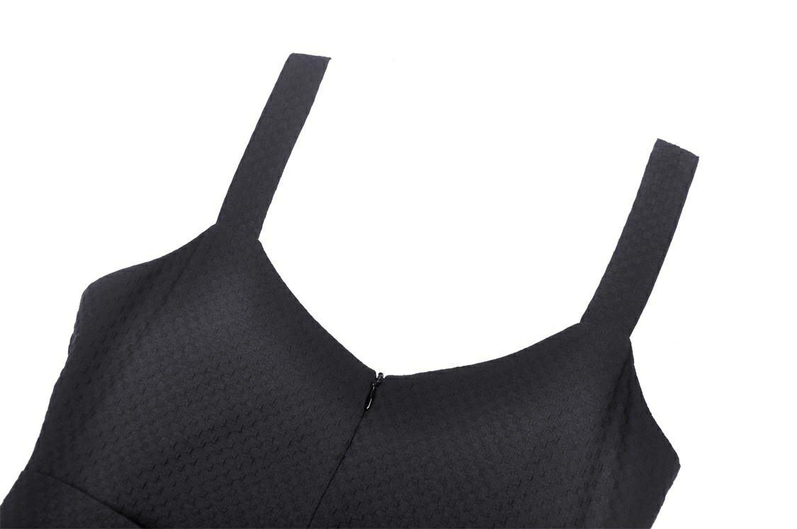 Close-up of elegant black dress showcasing textured fabric and sleek straps, perfect for chic parties.