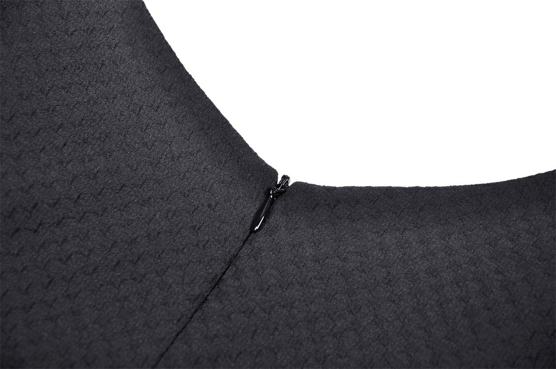 Close-up of the back zipper detail on an elegant black dress, showcasing chic craftsmanship.