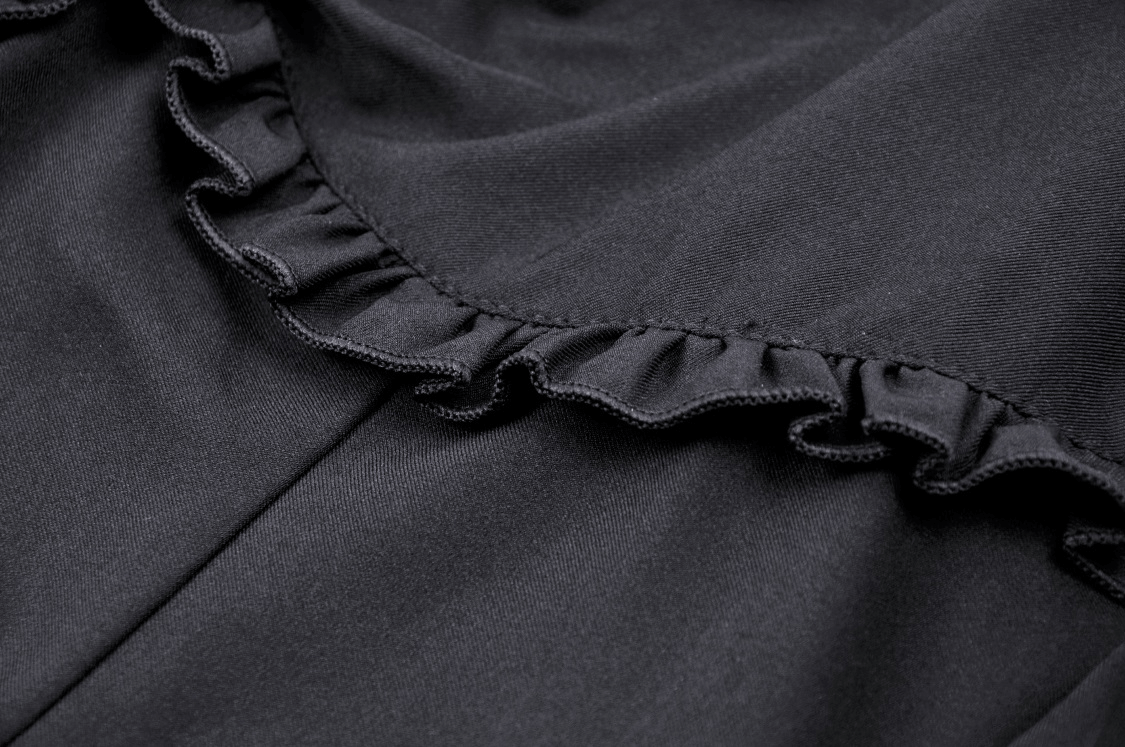Close-up of black dress fabric featuring elegant ruffle detailing, highlighting gothic-inspired design elements.