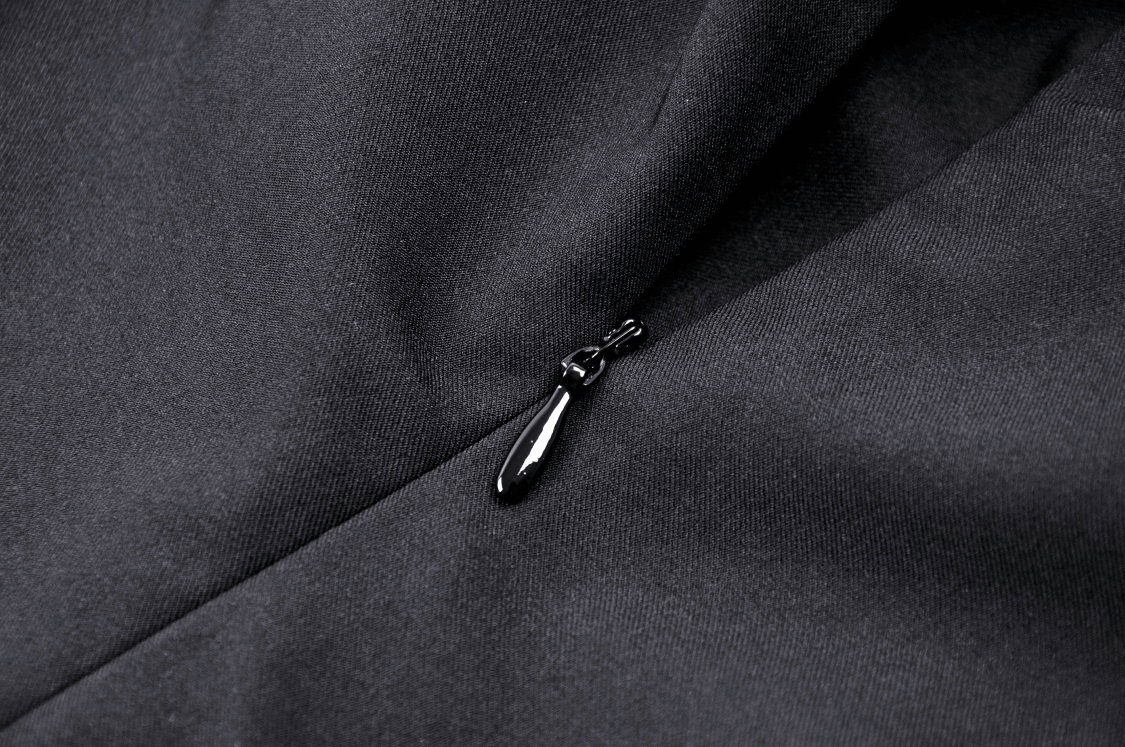 Close-up of a black dress zipper detail, highlighting elegant craftsmanship and gothic-inspired style.