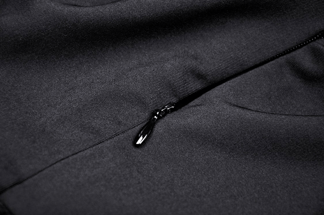 Close-up of a sleek black dress featuring a stylish zipper detail for a chic and modern look.