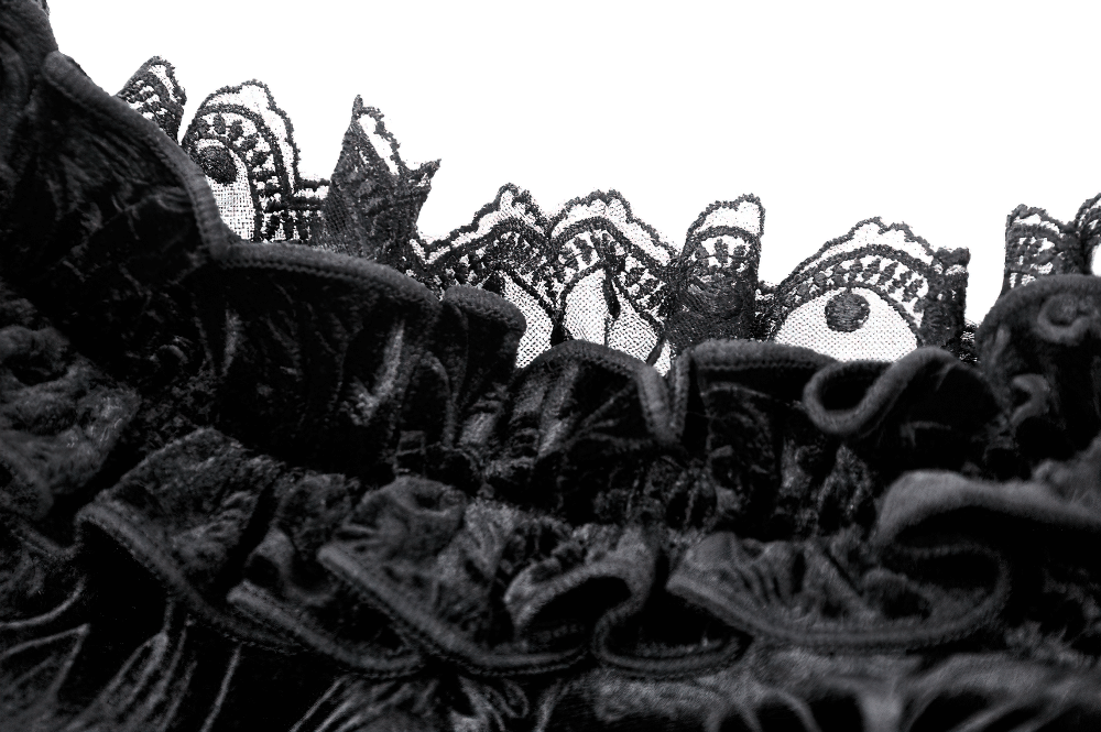 Close-up of intricate black lace detailing on a flared sleeve bolero, perfect for elegant evening outfits.