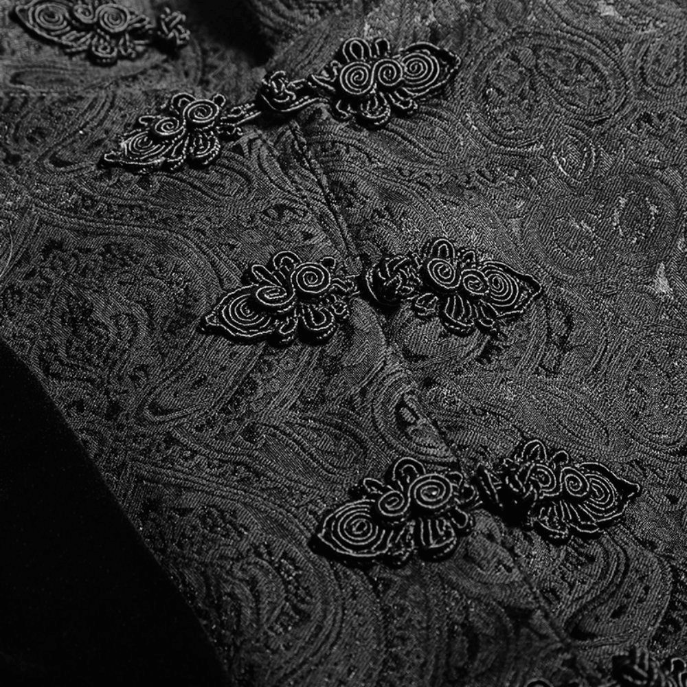 Close-up of intricate black floral jacquard pattern and ornate buttons on a Gothic swallowtail vest.