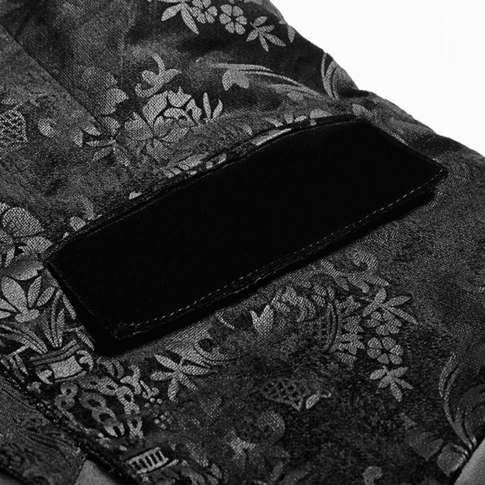 Close-up of elegant black floral jacquard fabric featuring a velveteen patch, showcasing gothic design details.