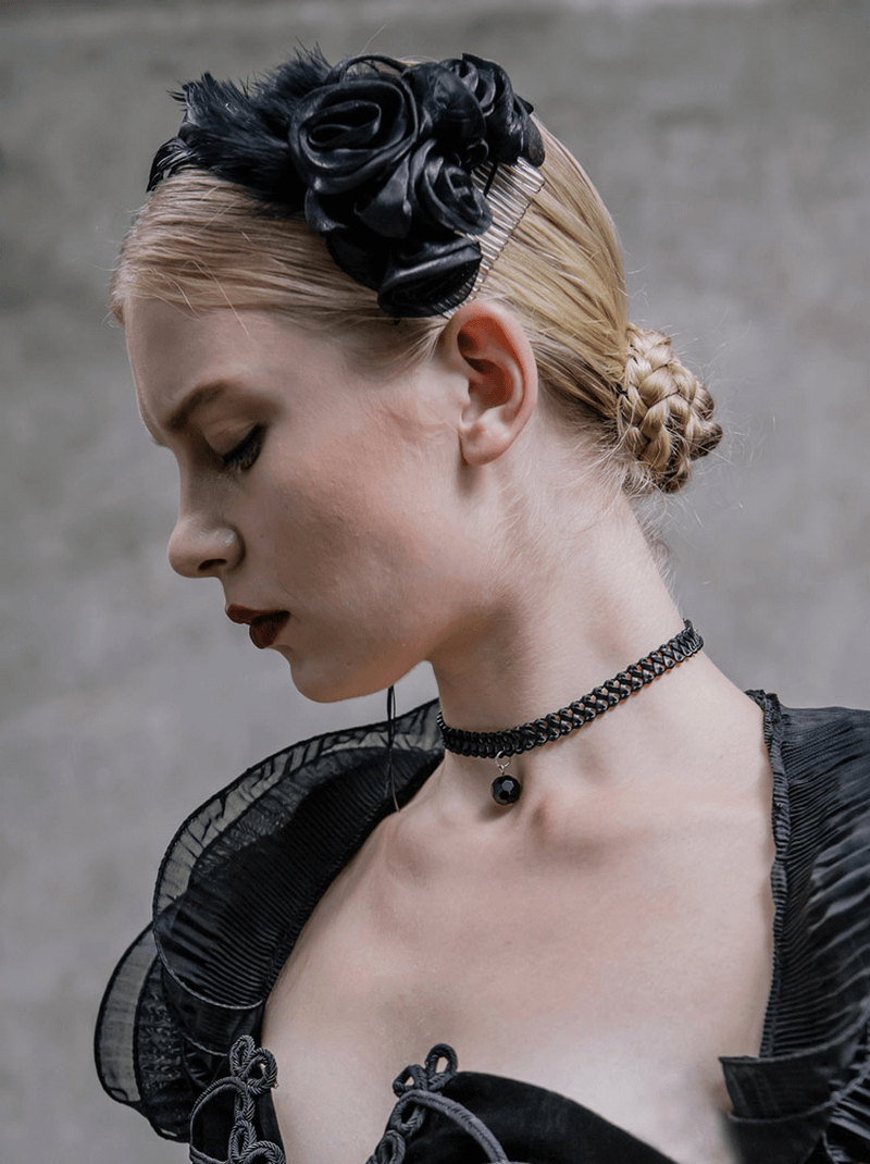 Elegant black flower hair clip with feathers worn by a model in gothic attire, showcasing stylish floral hair accessories.