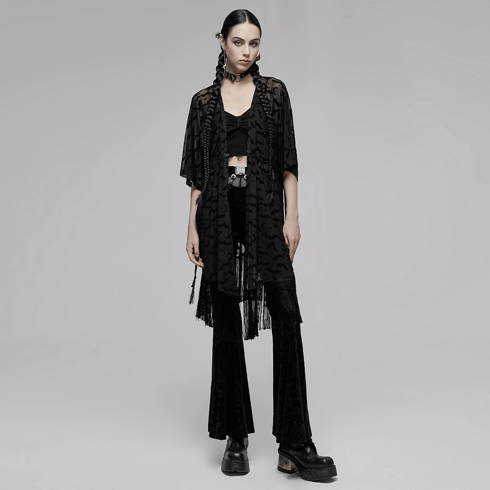 Woman wearing an elegant black lace bat print kimono-cape with tassels over a black outfit, highlighting a gothic style.
