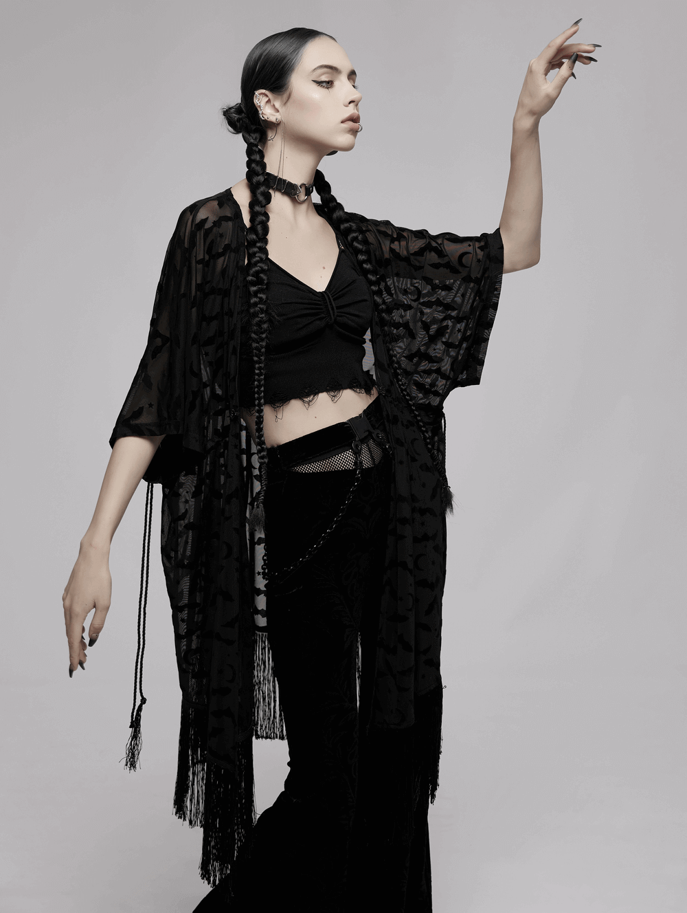 Model showcasing an elegant black lace bat print kimono-cape with tassels, exuding gothic charm.