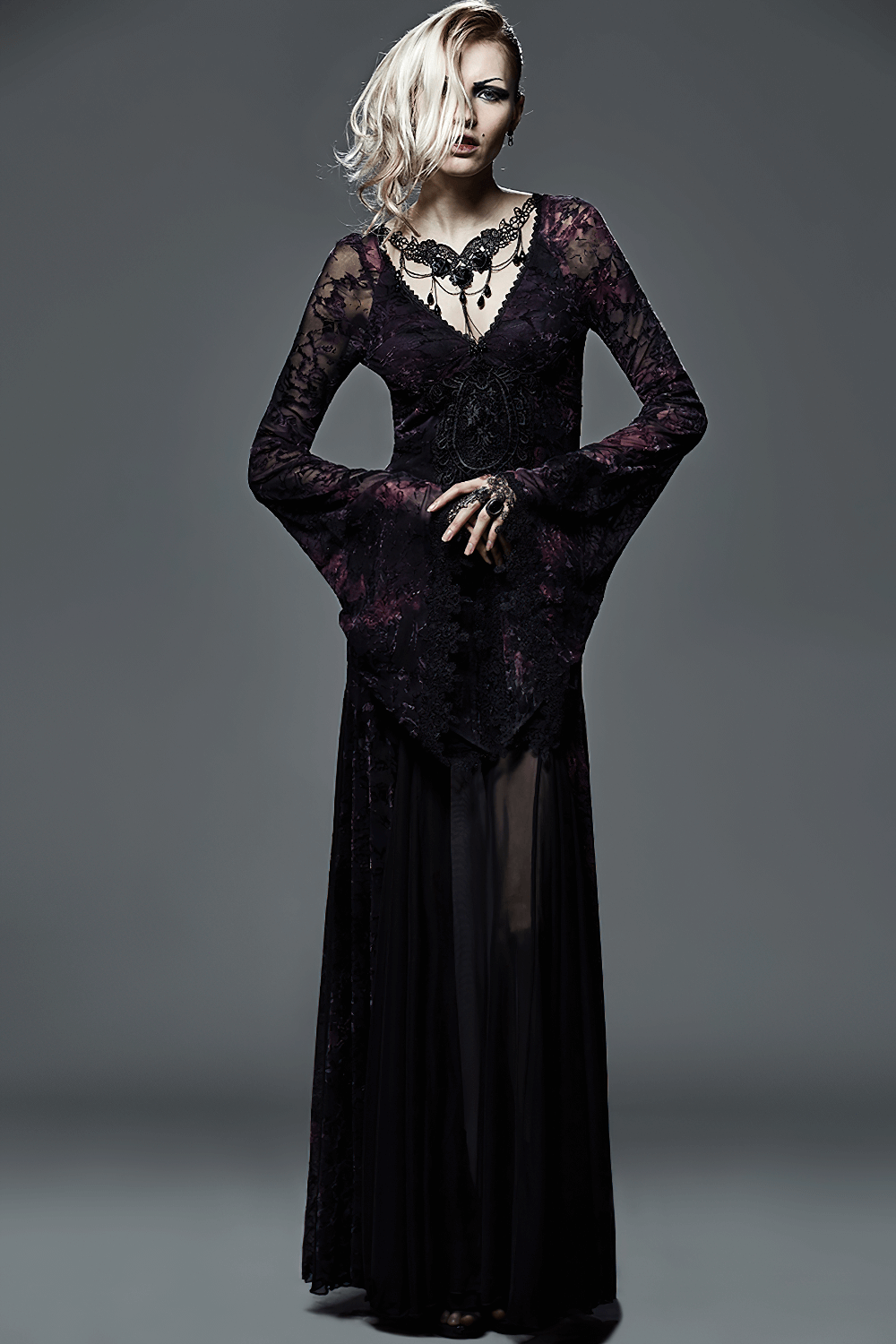 Elegant woman in a black lace gown with long sleeves, showcasing a Gothic style choker; perfect for dark, artistic fashion.