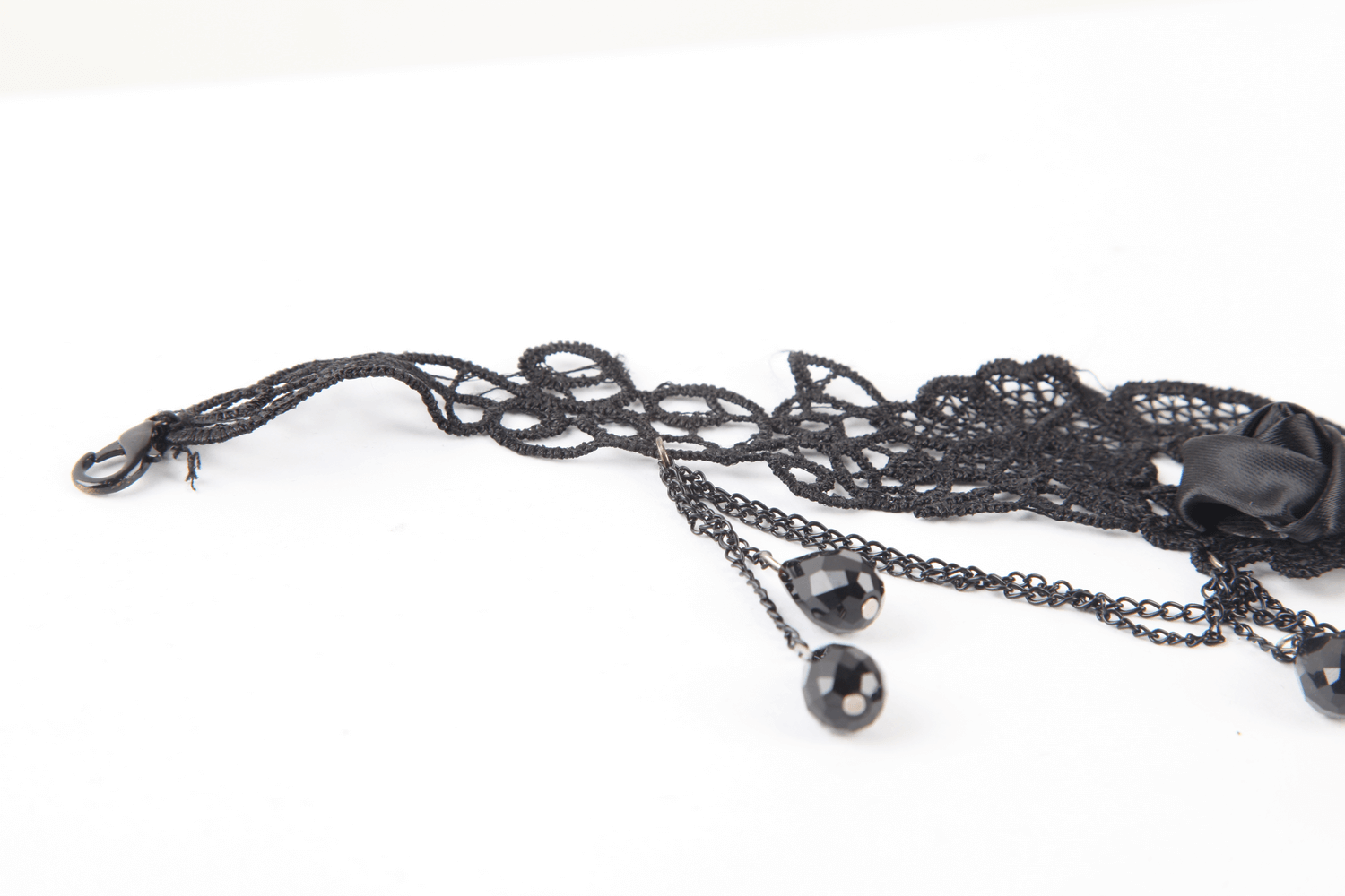 Close-up of an elegant black lace choker featuring intricate floral patterns and stylish drop details.
