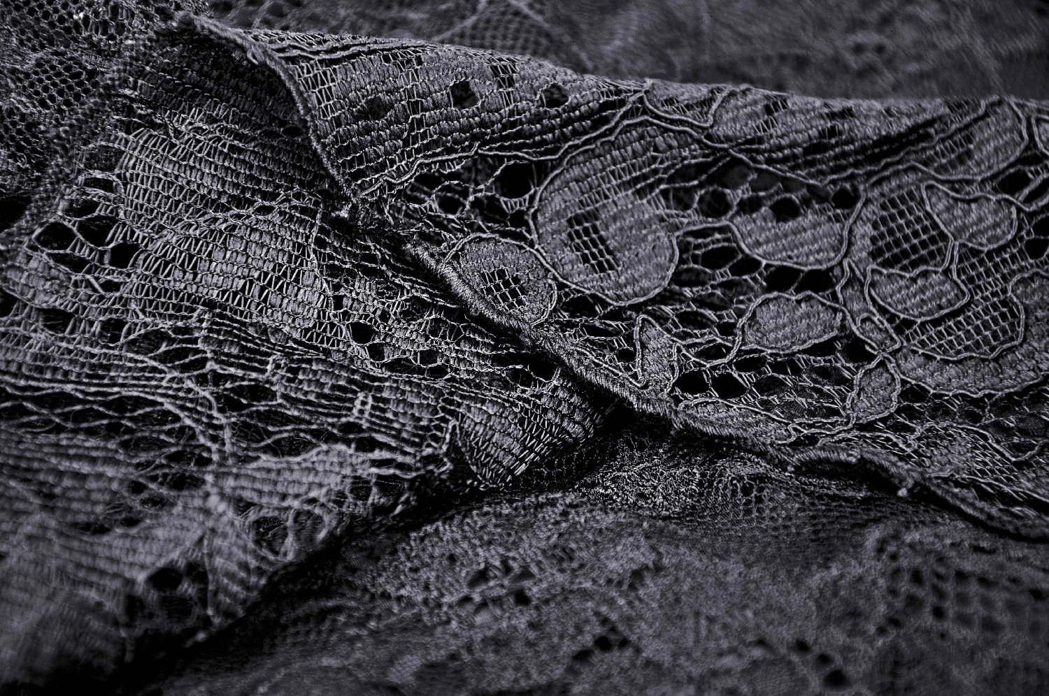 Close-up of elegant black lace fabric showcasing intricate patterns and textures, perfect for gothic fashion.