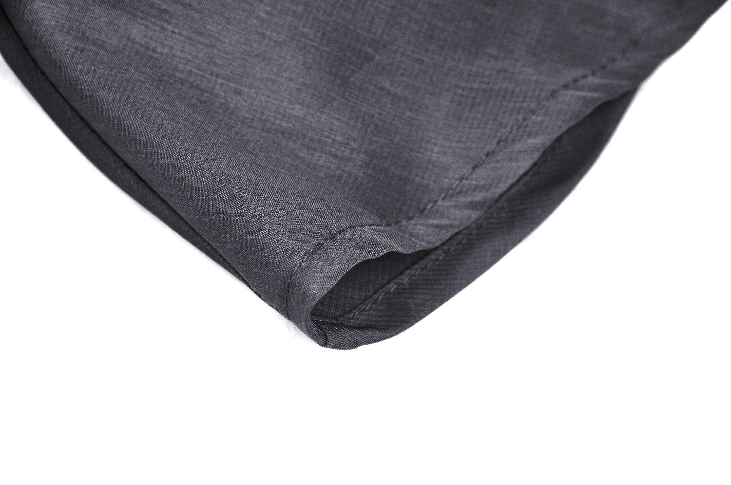 Close-up of the hem detail of a sleek black fabric, showcasing a smooth finish and delicate stitching.