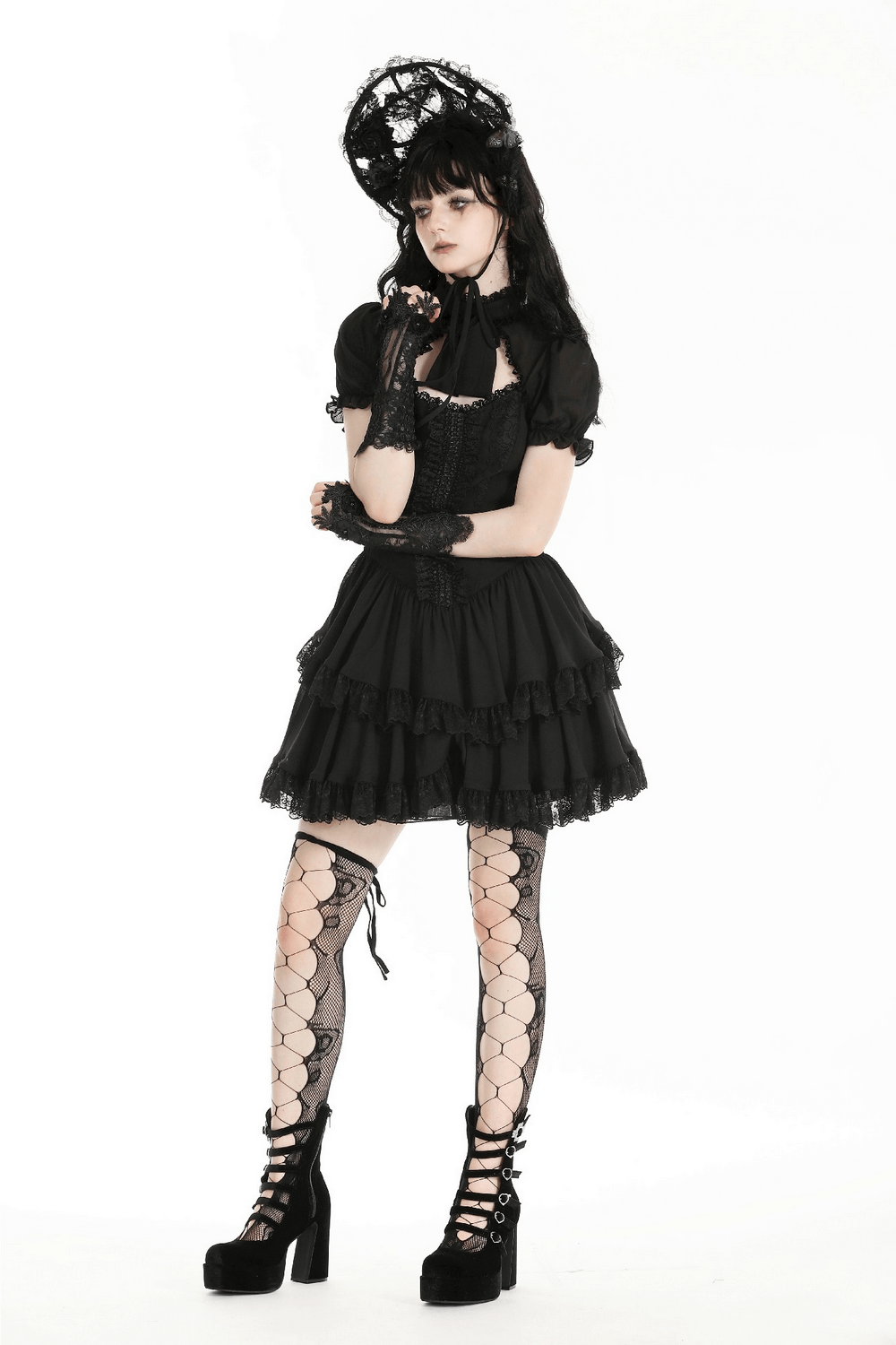 Chic model in black lace dress and fingerless gloves, showcasing elegant gothic fashion style.