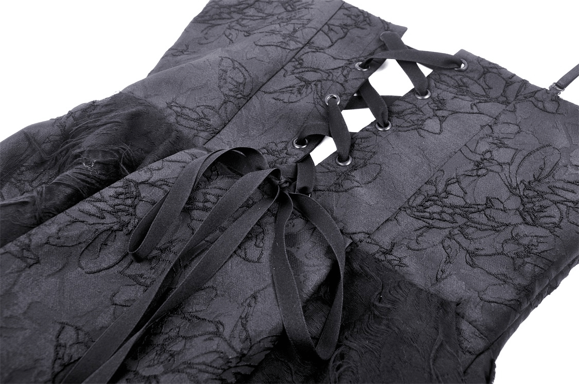Close-up of elegant black lace dress with floral detailing and stylish lace-up design.