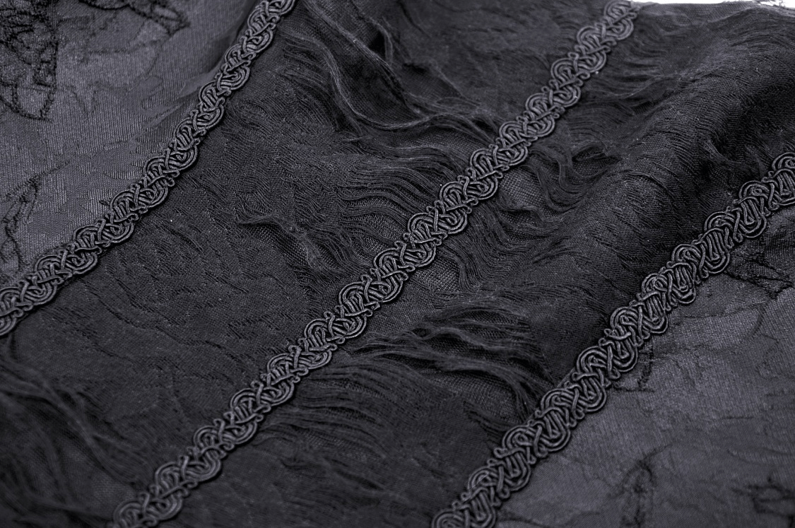 Close-up of textured black lace fabric featuring intricate floral details and braided trim.