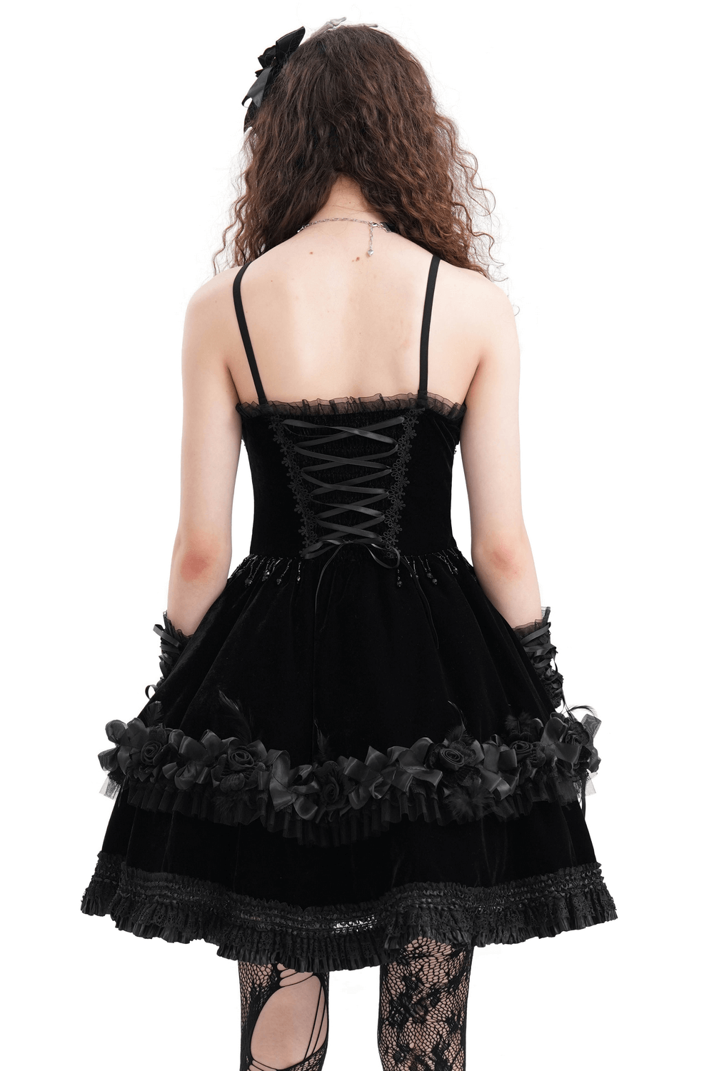 Back view of an elegant black lace evening dress with floral accents and lace-up detail, exuding chic sophistication.