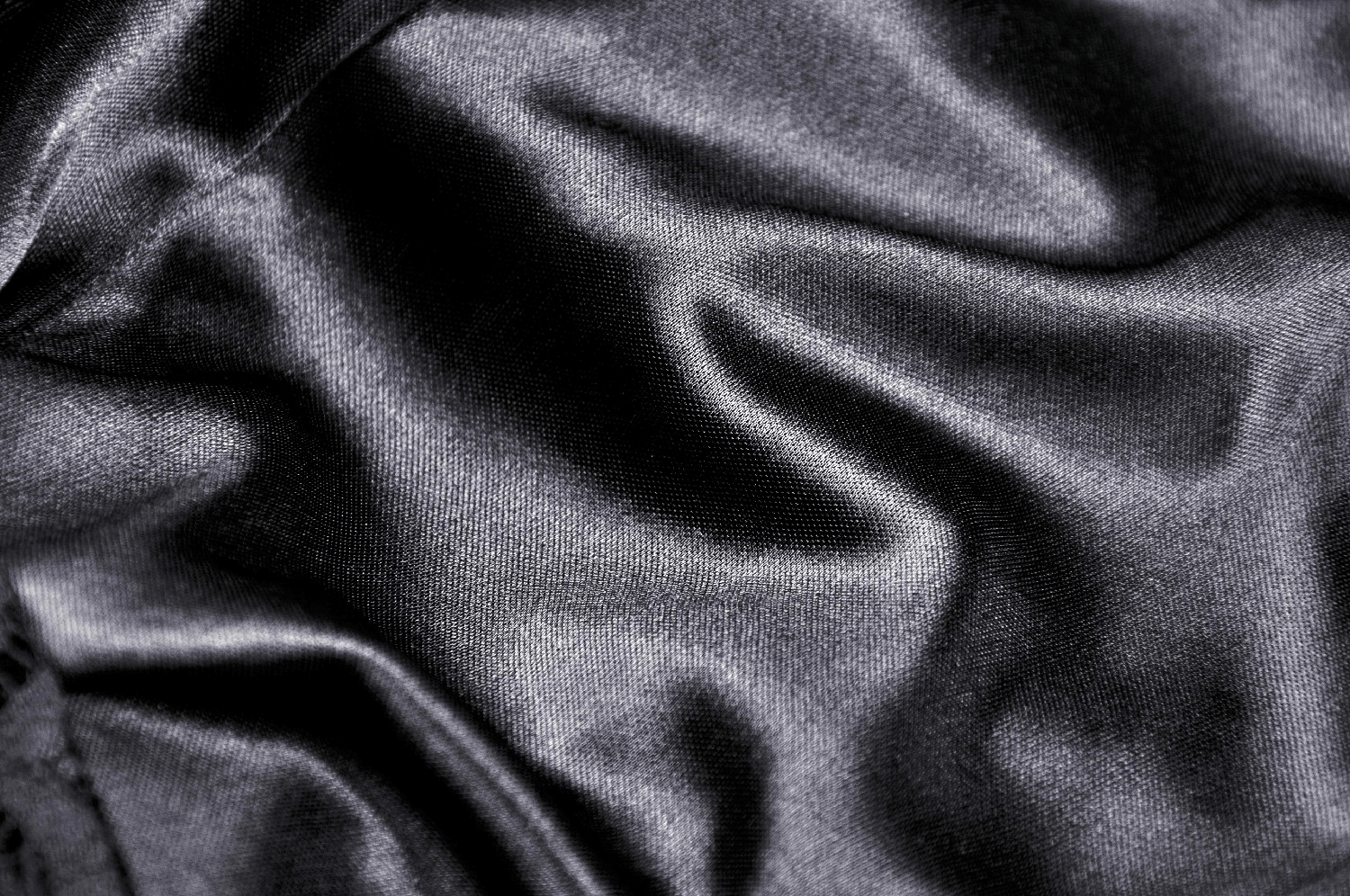 Close-up of luxurious black satin fabric, showcasing smooth texture and elegant draping.
