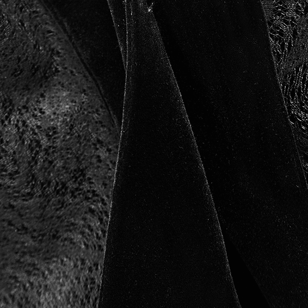 Close-up of luxurious black velvet fabric highlighting the soft texture of a Gothic hooded cloak.