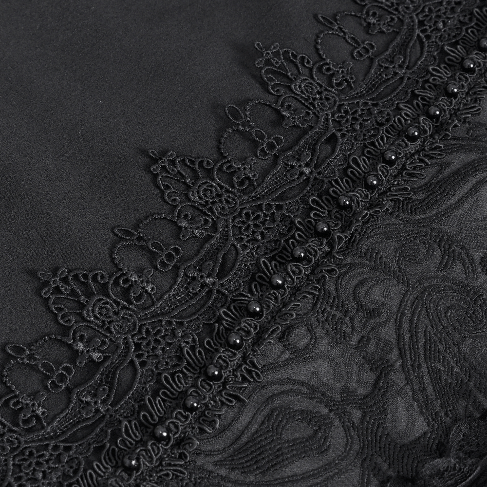 Close-up of elegant black lace detailing with intricate patterns and beads on fabric.