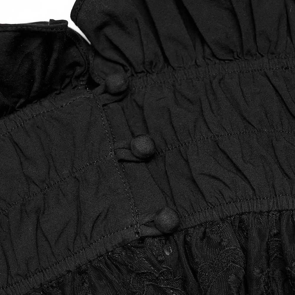 Close-up of the elegant black lace off-the-shoulder camisole showing ruffle detailing and buttons.