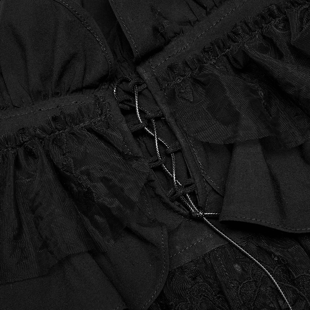 Close-up of black lace ruffle detailing and drawstring closure on an elegant off-the-shoulder camisole.