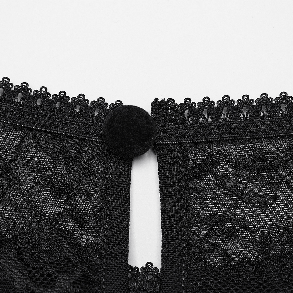 Close-up of the intricate button detail on the back of a black lace blouse with delicate lace trim.
