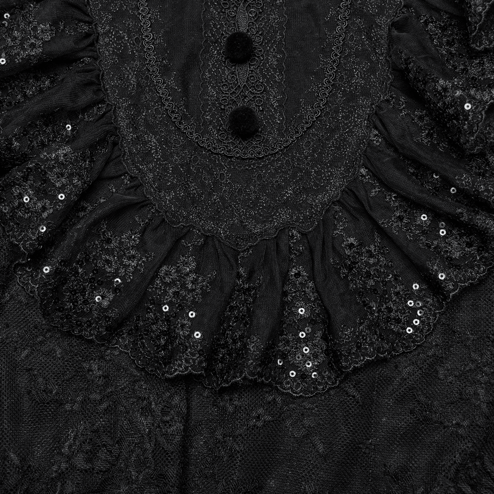 Detail of elegant black lace blouse with ruffle and sequins embellishment, showcasing intricate design and button details.