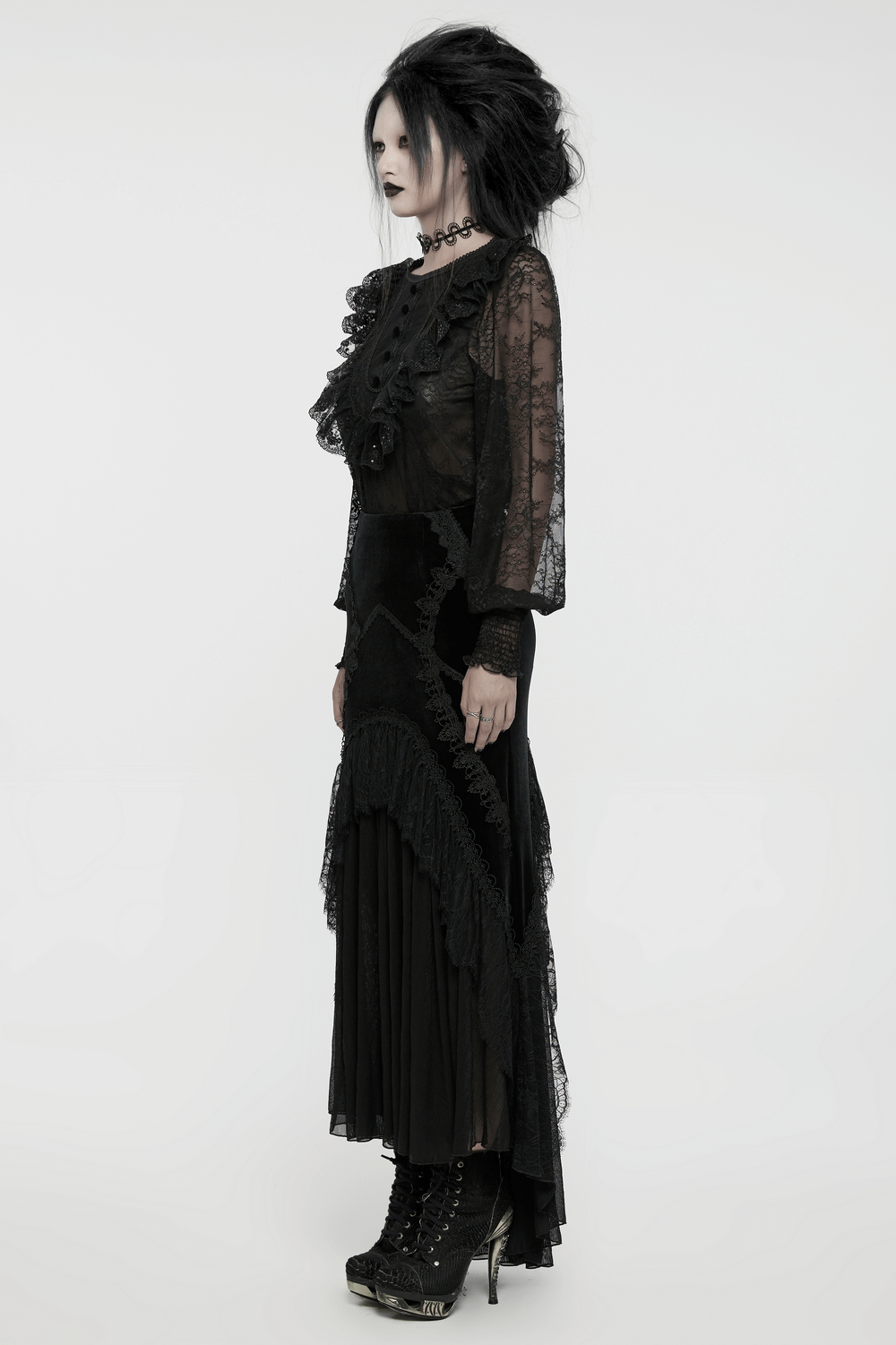 Elegant black lace blouse with ruffles, sequins, and gothic style, worn with a flowing skirt and stylish boots.