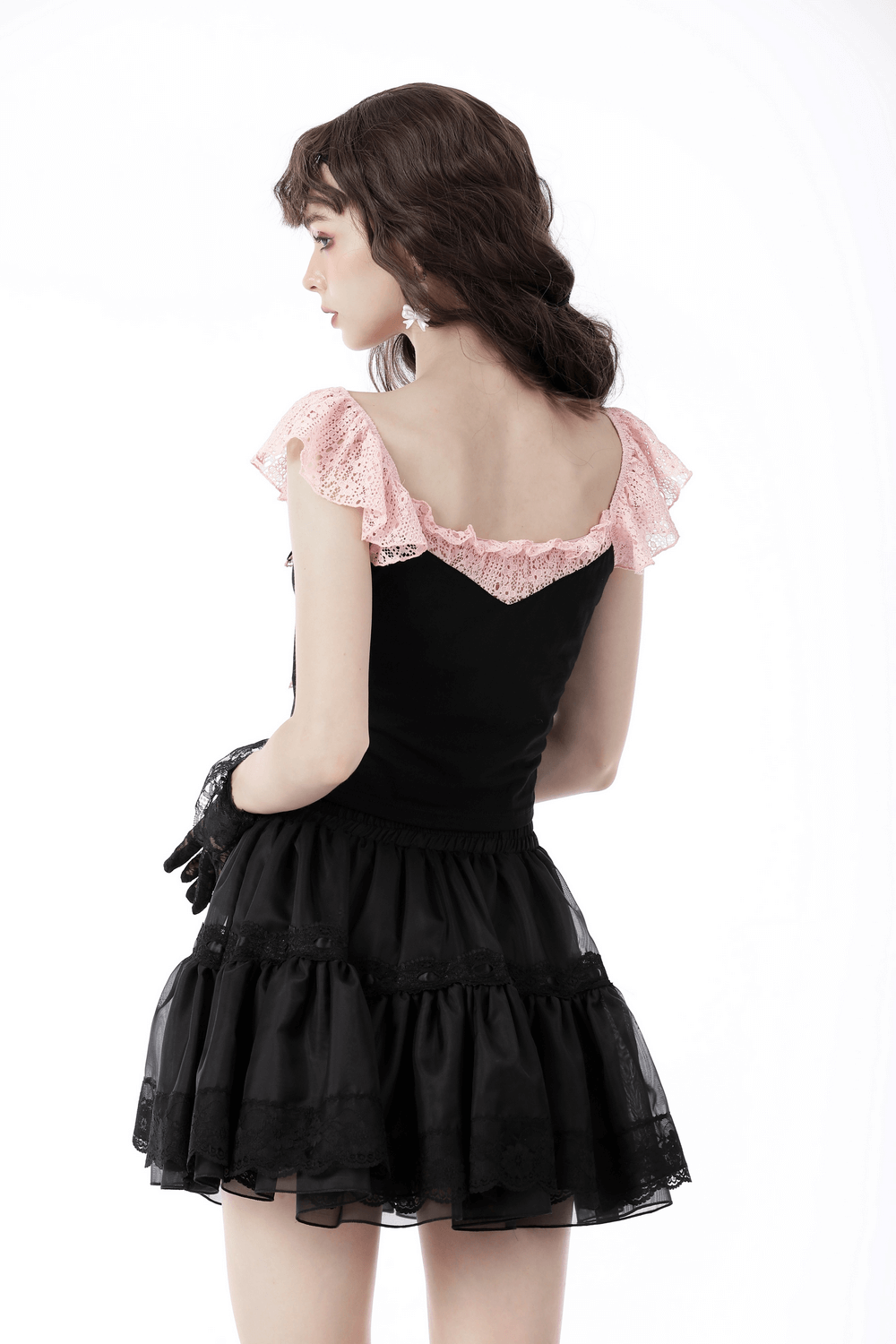 Back view of a gothic-inspired dress with pink lace sleeves and a black ruffled skirt, perfect for evening wear.