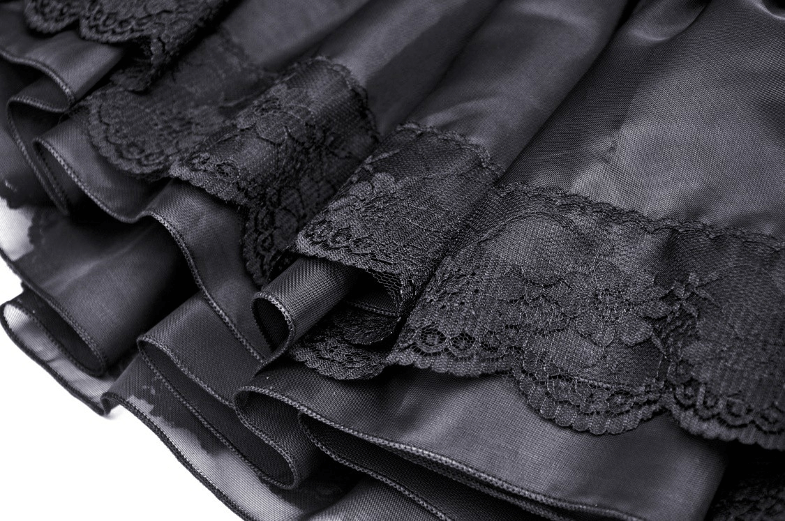 Close-up of elegant black lace skirt showing intricate lace patterns and ruffled hem details.