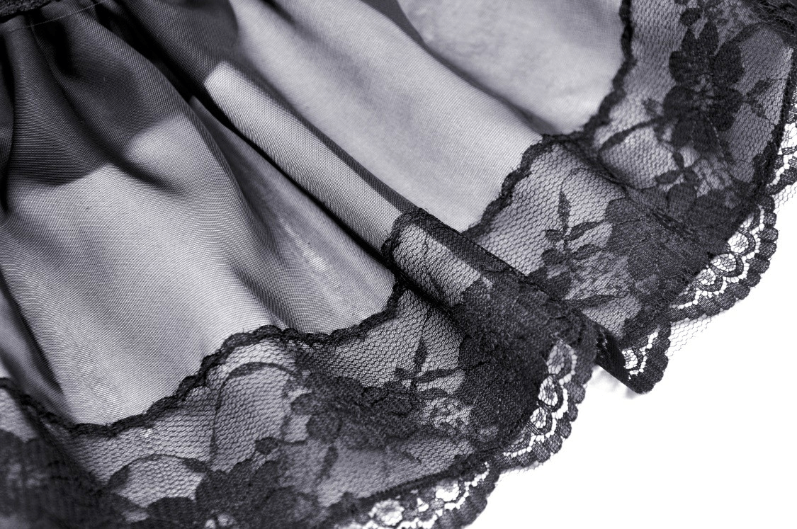 Close-up of intricate black lace hem showcasing elegant patterns for gothic-inspired evening wear.