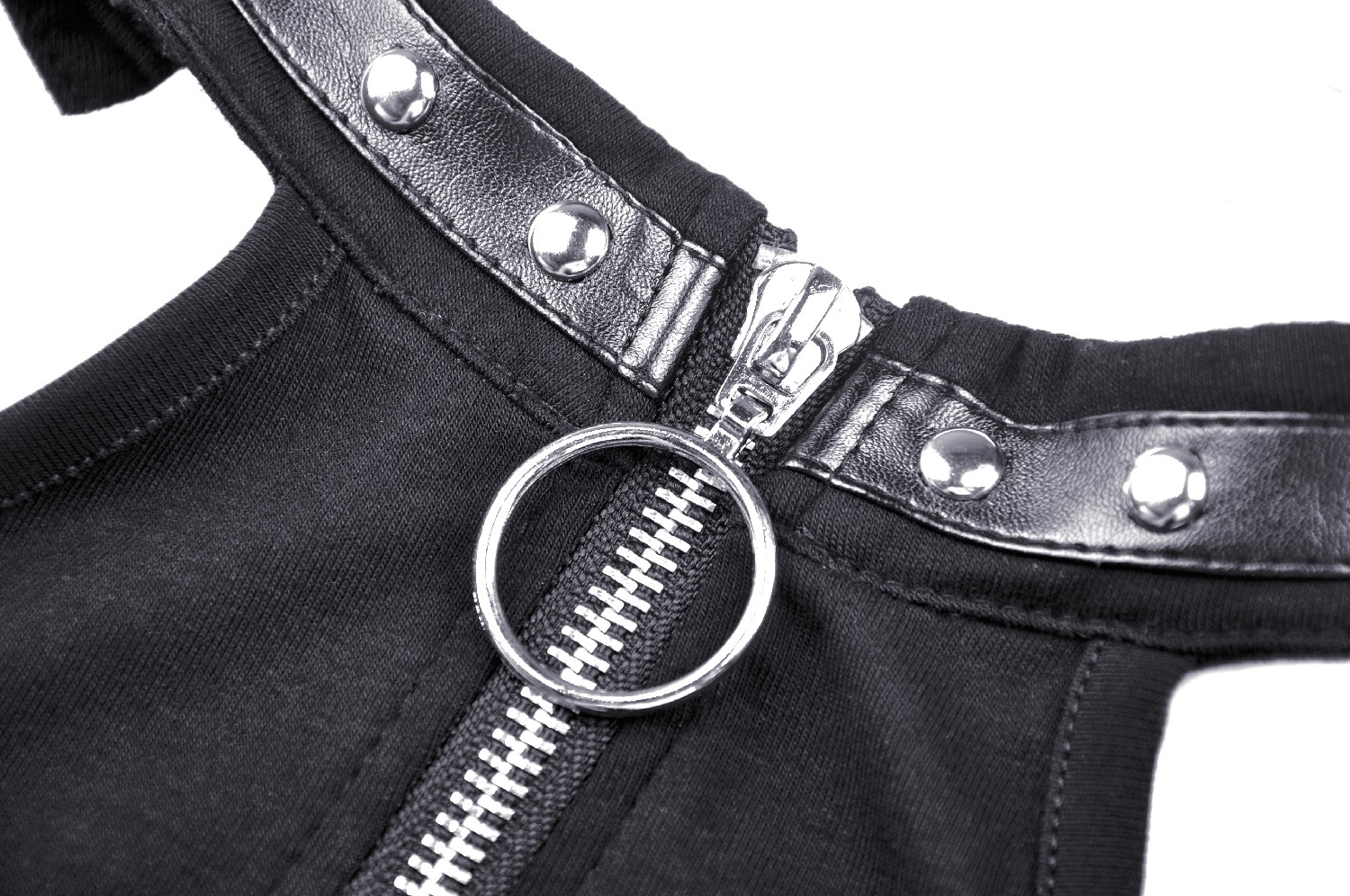 Close-up of a stylish black dress with silver zipper detail and decorative snaps, showcasing edgy fashion elements.