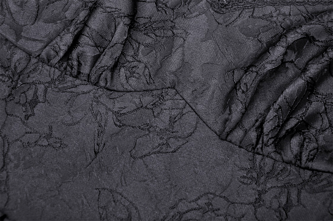 Close-up of elegant black lace fabric showcasing intricate floral patterns, perfect for a stylish evening dress.
